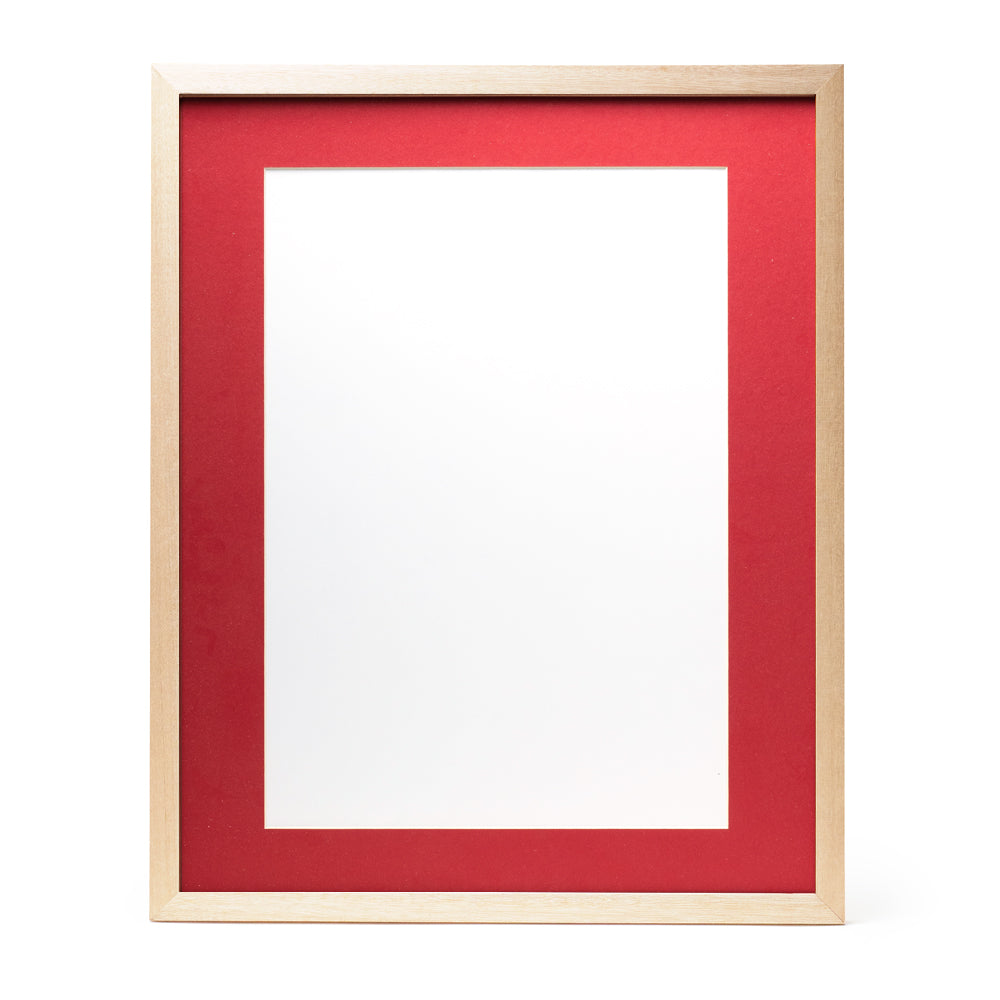 A wooden frame with natural stain finish and a bright red pre-cut framing matt.